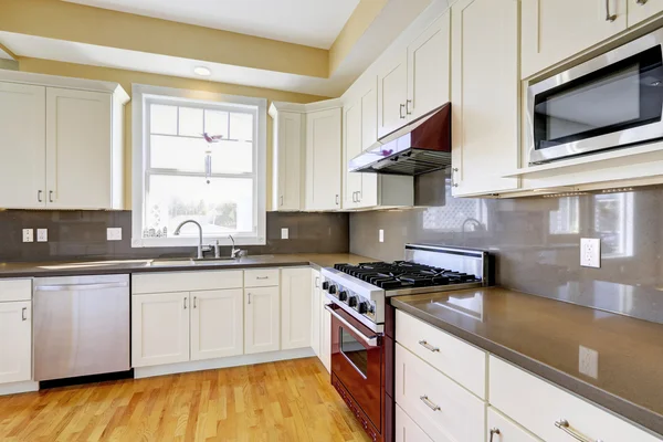 White kitchen with burgundy stove and grey counter tops — Stock Photo, Image