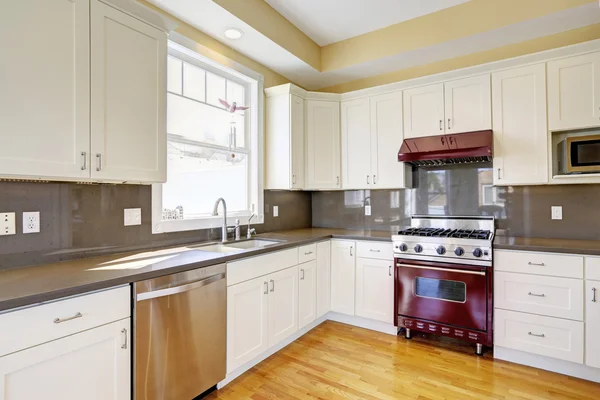 White kitchen with burgundy stove and grey counter tops — Stock Photo, Image