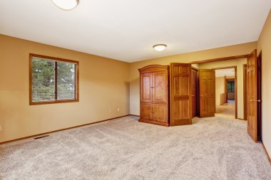 Boş yatak odası içi yumuşak şeftali renginde ve gardıroplu.