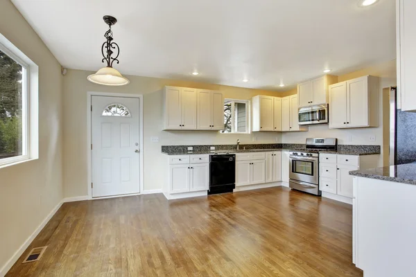Кухня с белыми шкафами и гранитными топами — стоковое фото