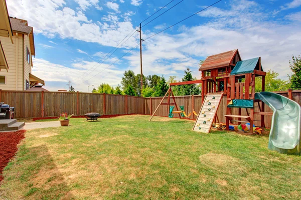 有篱笆的后院，与孩子们的游乐场 — 图库照片