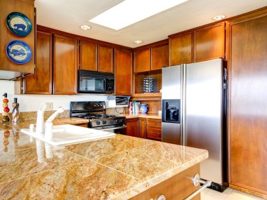 Bright kitchen interior with steel appliances clipart