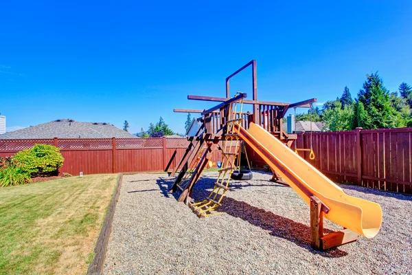 Omheinde achtertuin met speeltuin voor kinderen — Stockfoto