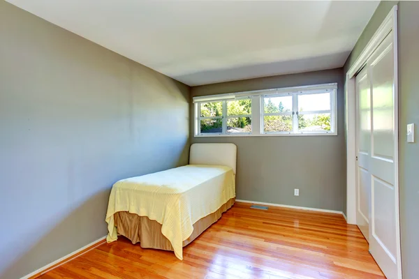 Interior de la casa vacía. Dormitorio gris con cama individual — Foto de Stock