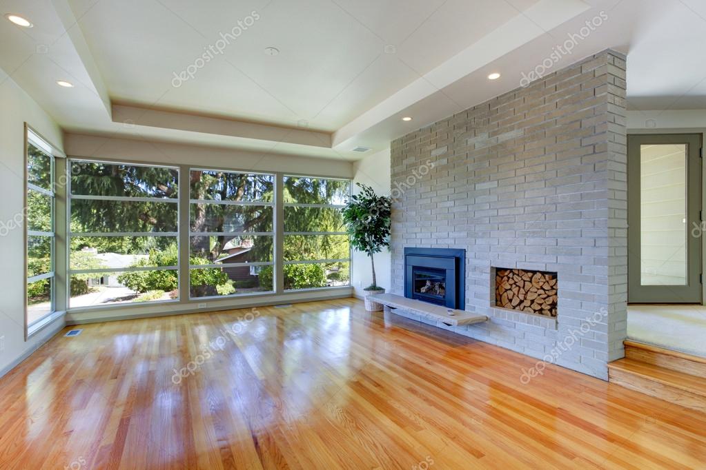 Leeg huis interieur. woonkamer met glazen wand en bakstenen muur ... Openhaard woonkamer interieur