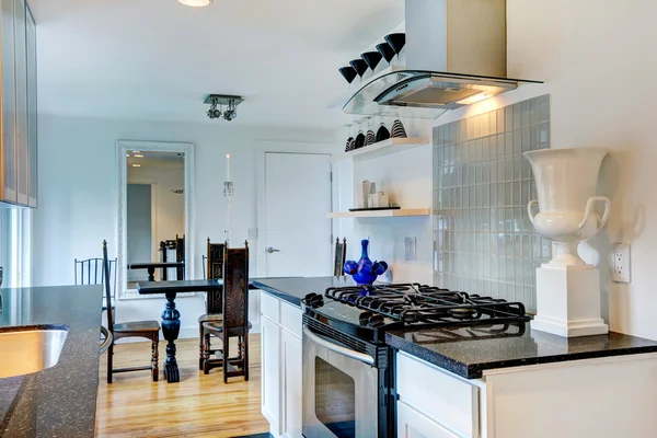 Keuken met zwart granieten interieur toppen en gesneden houten tafel — Stockfoto