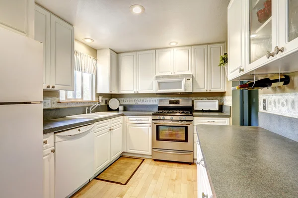 Простая белая кухня с гранитными верхушками — стоковое фото