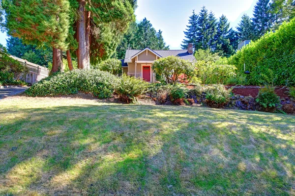 Casa com porta de entrada vermelha. Vista paisagem jardim dianteiro — Fotografia de Stock