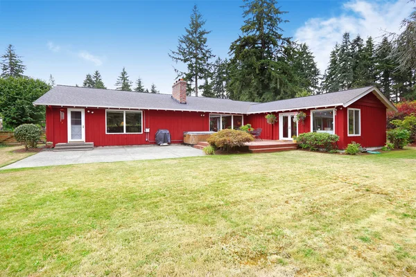 Heldere rode huis met staking dek en patio gebied — Stockfoto