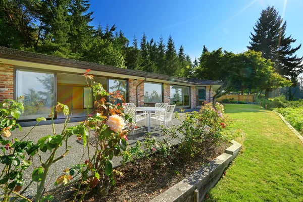 Linda casa de tijolo com porão walkout e paisagem — Fotografia de Stock