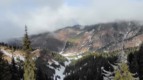山の中でリュックハイキングを持つ男 寒い天気 丘の上の雪 山は雲で覆われている 冬のハイキング — ストック動画