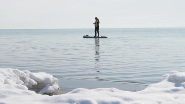 Hombre Remando Invierno Stand Paddle Surf Orilla Cubierta Nieve Aguas — Vídeos de Stock