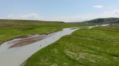 Bir grup turist nehirdeki SUP tahtasının üzerinde kürek çekiyor. Dağ nehri vadisi. Su sporları