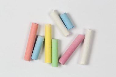 Beyaz kağıt üzerinde renkli tebeşir parçaları, üst görünüm