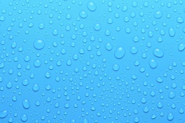 Açık mavi yüzeyde su damlalarına yakın çekim