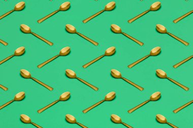 Yeşil yüzeyde altın kaşıklı desen