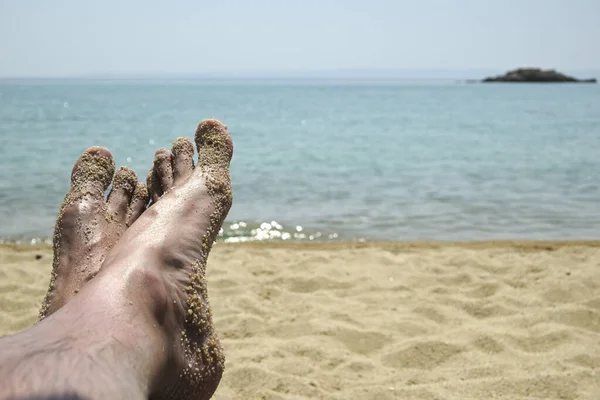 Closeup Των Ποδιών Του Ανθρώπου Χαλαρώνοντας Δίπλα Στη Θάλασσα — Φωτογραφία Αρχείου