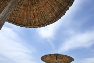 Mavi gökyüzü olan bir sahil şemsiyesi altında, yaz konsepti.