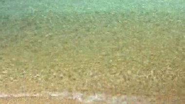 Güzel bir kumsalın kumsalına düşen küçük dalgalar, gerçek zamanlı.