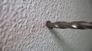 Yavaş çekimde matkap ucu duvarda bir delik açıyor.
