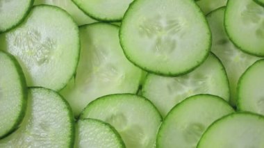 closeup of freshly cut cucumber slices rotating