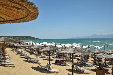 popular beach resort with sunbeds and straw umbrellas