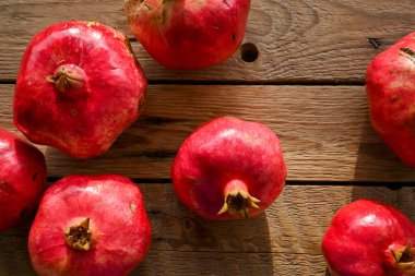 Eski ahşap masada organik nar manzarası, doğal ışıklandırma.