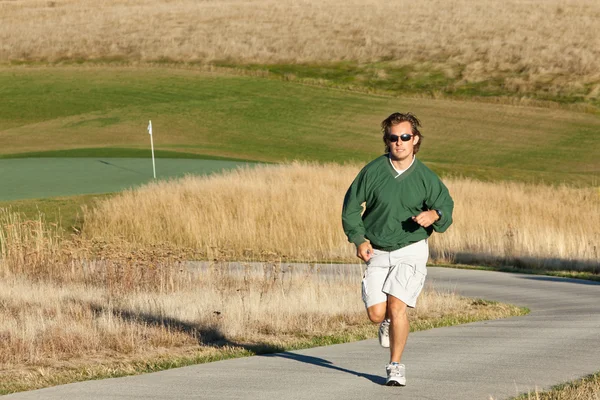 Człowiek joggingu na polu golfowym — Zdjęcie stockowe