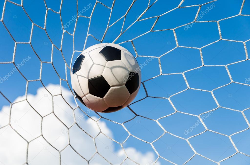 Soccer football in Goal net with the sky field.