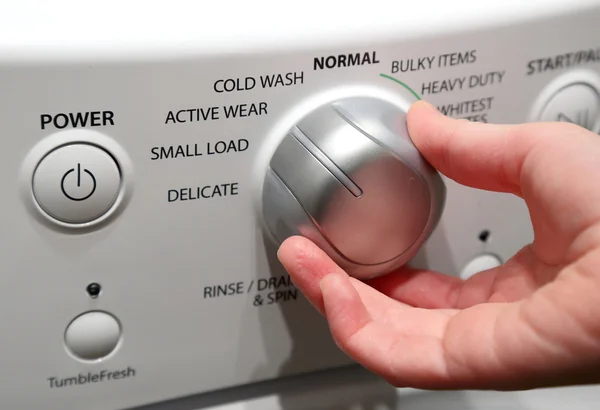Mão girando na máquina de lavar — Fotografia de Stock