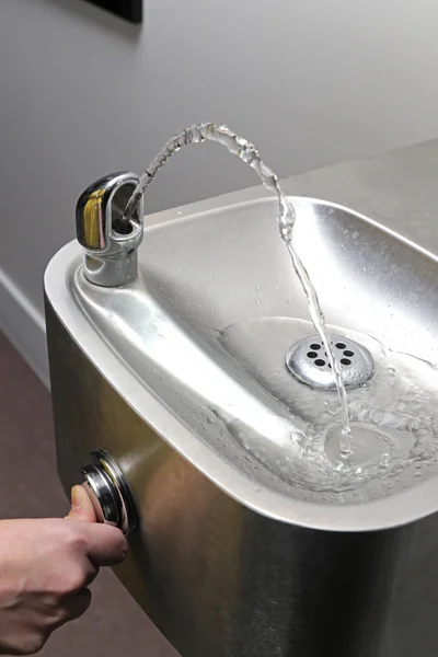 Thumb press the drinking water fountain — Stock Photo, Image