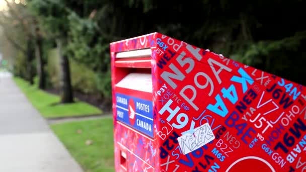 Kvinna att placera mail i en kanadensisk brevlåda — Stockvideo