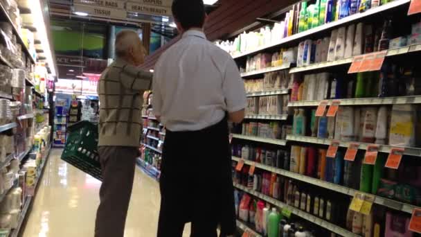 Homem pedindo informações com coisas no supermercado — Vídeo de Stock