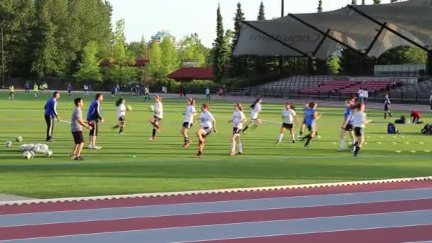 Studenten track & field training met caps — Stockvideo