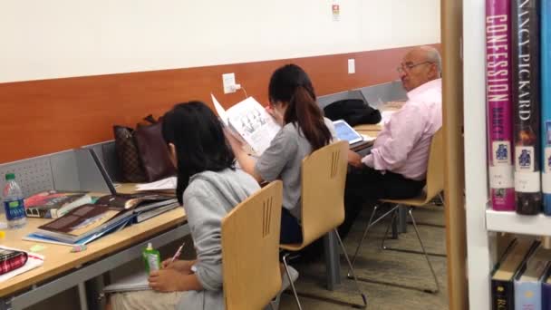 Gente estudiando en la biblioteca — Vídeo de stock