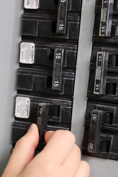 Woman turning off the light-switch in the hall — Stock Photo, Image