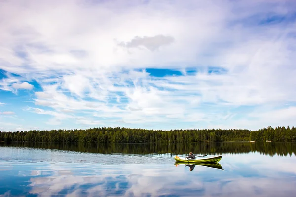 Pescatore naviga su una barca verde sul lago — Foto Stock