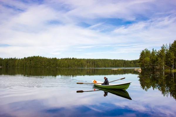 Fisherman sails on a green boat on the lake — Stock Photo, Image