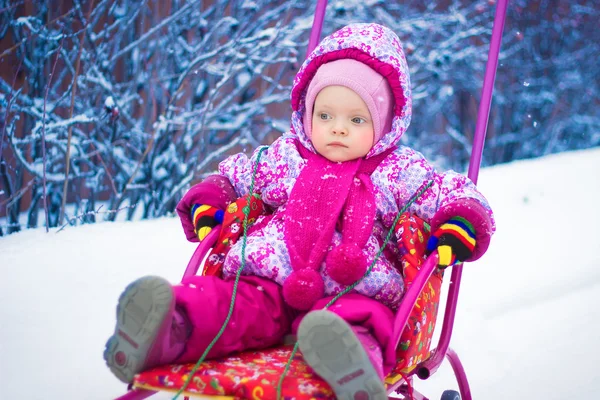 Pequeño niño está montando en un trineo en invierno — Foto de Stock