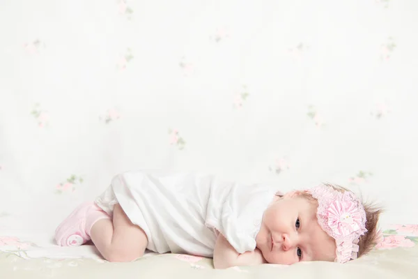 Beautiful newborn girl holding a flower — Stock Photo, Image