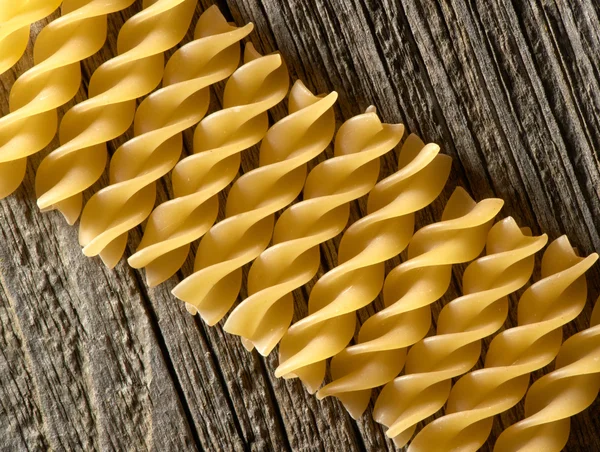 Pasta spiral on the wooden background — Stock Photo, Image