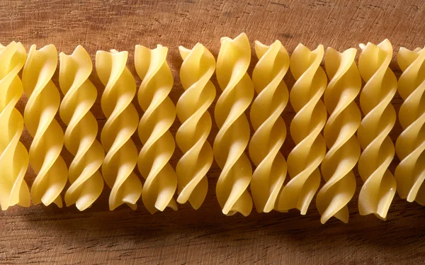 Pasta spiral on the wooden background — Stock Photo, Image