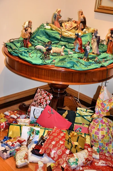Christmas gifts and table with crib — Stock Photo, Image
