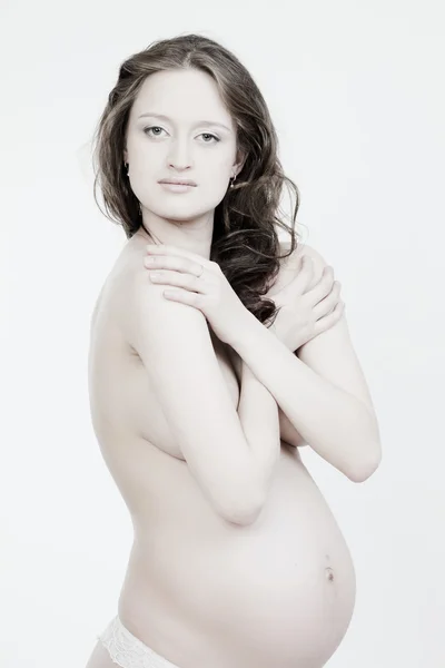Bella donna incinta su uno sfondo bianco — Foto Stock