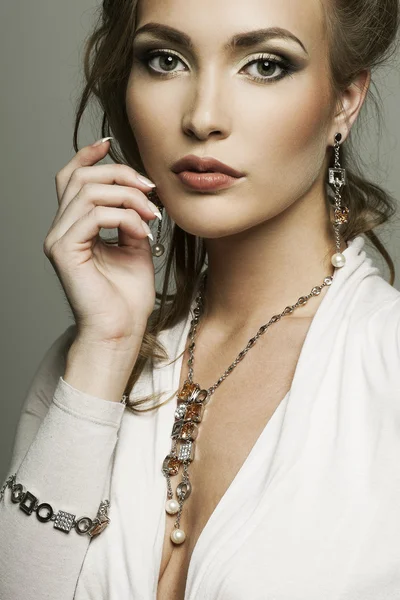 Portrait d'une belle femme avec un maquillage parfait portant des bijoux Image En Vente