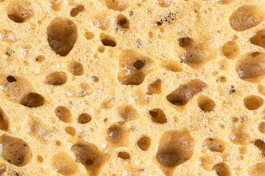 Plastik sarı sünger arkaplanının makro görüntüsü. Yakın çekim dokusu. Sarı sünger deseni. Sünger dokusu arka planı. Arkaplan için sarı sünger