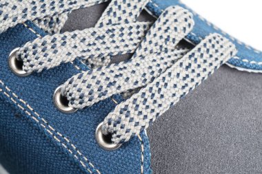 Makro, gri örgü deri ayakkabıları bağlamış. Yeni spor ayakkabısının bağcıkları birbirine çok yakın. Modern tekstil eğitmenlerinin elastik bağcıkları