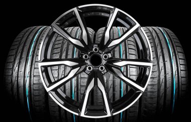 Car alloy wheel and tyre isolated on black background. New alloy wheel with tire for a car on a black background. Alloy rim isolated. Car wheel disc. Car spare parts