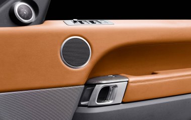 Araba kapısı, kahverengi deri desenli ve dikişli lüks modern arabanın içinde. Düğme kontrolünü değiştir. Modern araba iç dekorasyonu. Turuncu delinmiş deri.