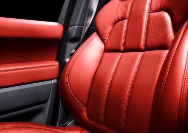 Modern lüks arabanın içi kırmızı deri. Kırmızı delikli deri koltuk detayları ve beyaz dikişler. Prestij arabasının içi. Rahat delinmiş deri koltuklar. Delinmiş deri..